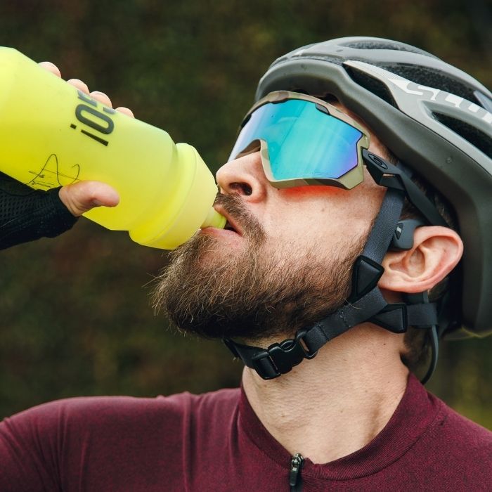 Homme cycliste qui boit de l'eau